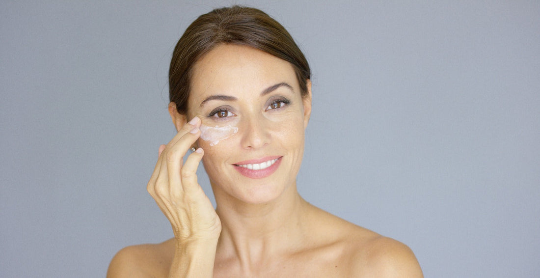 Woman applying eye cream under eye